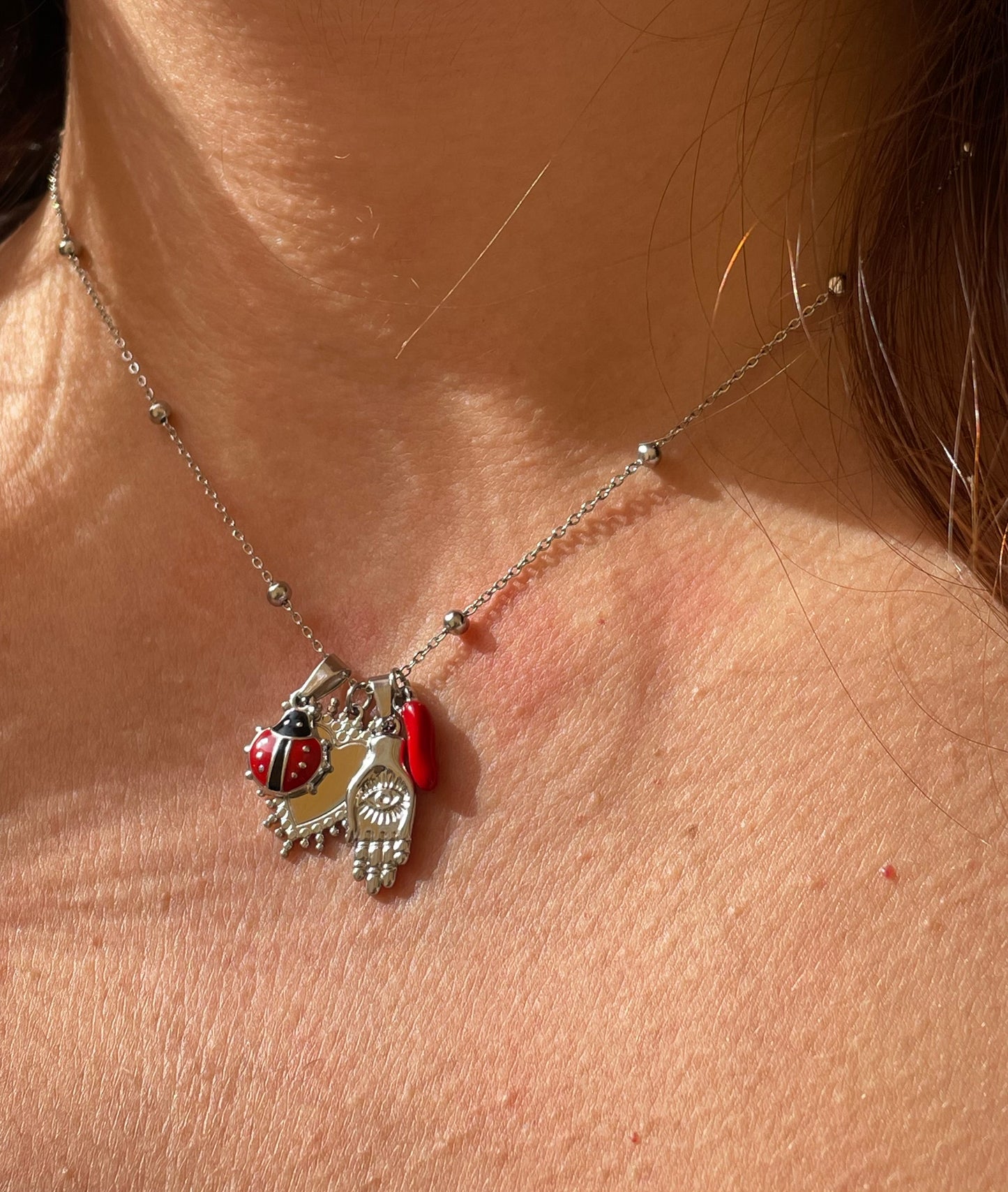 Collana con corno, coccinella, sacro cuore e mano di protezione in 2 colori