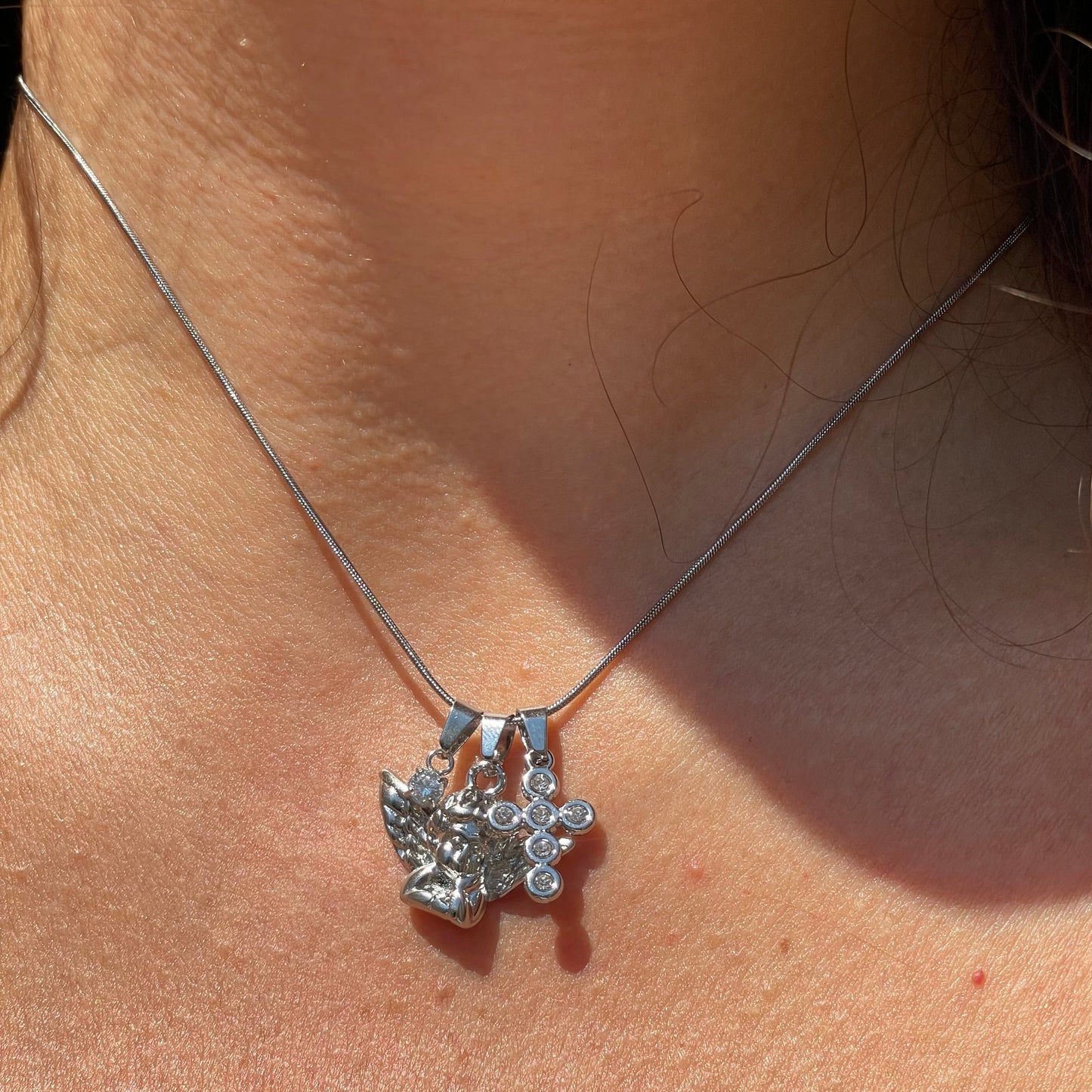 Collana angelo con croce e punto luce in 2 colori